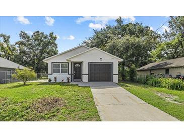 Charming single-story home with a well-maintained lawn, dark trim, and an attached garage at 9413 5Th Ave, Orlando, FL 32824
