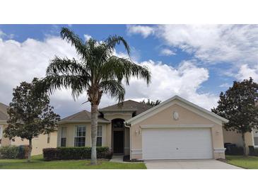 Charming single-Gathering home with a well-manicured lawn, mature trees, and a two-car garage at 189 Minniehaha Cir, Haines City, FL 33844