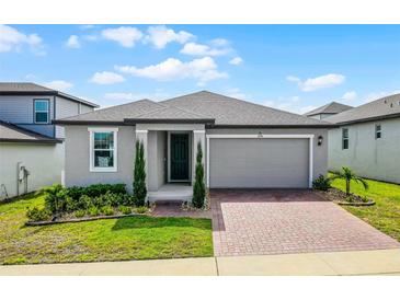Charming single-story home featuring a two-car garage and a well-manicured lawn at 2296 Crossbow St, Clermont, FL 34715