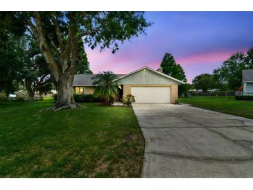 Well-maintained home with a two-car garage and a spacious driveway at dusk at 4221 Meadowbend Ct, Lakeland, FL 33811