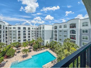 Expansive view of the community pool surrounded by lush tropical landscaping and resort-style amenities at 202 E South St # 5050, Orlando, FL 32801