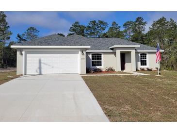 Charming one-story home featuring an attached two-car garage, well-maintained lawn and manicured landscaping at 4887 Sw 159Th Lane Rd, Ocala, FL 34473