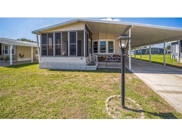 Charming home featuring a screened porch, covered parking, a bench, and well-maintained landscaping at 97 Parson Dr, Winter Haven, FL 33884