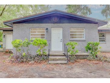 Charming single-story home featuring a gray brick exterior, well-maintained landscaping, and a welcoming front entrance at 1255 Pine St, Altamonte Springs, FL 32701