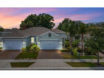 Charming home featuring a two-car garage, beautiful landscaping, and a brick driveway at 1890 Flora Pass Pl, Kissimmee, FL 34747
