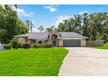 Charming brick home with well-manicured lawn and mature landscaping at 722 Swaying Palm Dr, Apopka, FL 32712