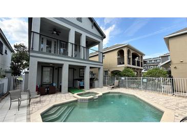 Resort style pool area featuring a spa, putting green, covered patio, and fenced yard perfect for outdoor living at 7810 Whitemarsh Way, Reunion, FL 34747