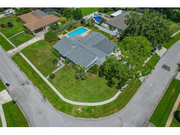 Gorgeous aerial view of home with beautiful lawn, swimming pool, and mature trees at 107 Elm N Sq, Lakeland, FL 33813