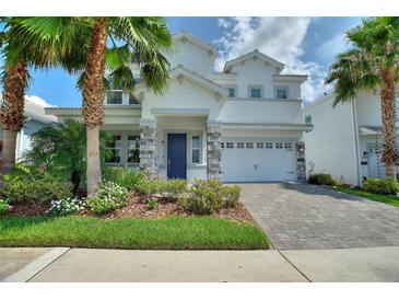 Charming two-story home featuring a well-manicured lawn, colorful landscaping, and a two-car garage at 1423 Bunker Dr, Davenport, FL 33896