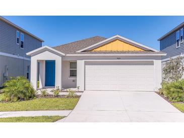 Charming single-Gathering home with a bright blue front door and attached two car garage at 766 Ambleside Dr, Haines City, FL 33844