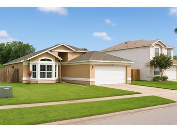 Charming single-story home featuring a well-manicured lawn and a two-car garage at 1510 Avleigh Cir, Orlando, FL 32824
