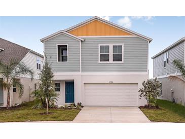 Charming two-story home with a two-car garage, light blue paint, and a beautifully landscaped yard at 770 Ambleside Dr, Haines City, FL 33844