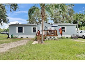 Charming single-story home with light blue siding, a cozy front porch, and a well-maintained lawn at 4854 Myrtle View N Dr, Mulberry, FL 33860