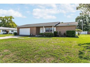 Charming single-story brick home featuring a well-manicured lawn and attached two-car garage at 5316 Dorman Rd, Lakeland, FL 33813