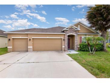 Charming single-story home with a well-manicured lawn, two-car garage, and inviting stone-accented entrance at , Kissimmee, FL 34758