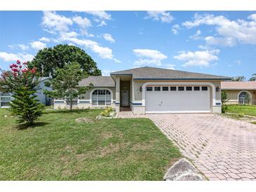 Charming one-story home with a brick driveway, well-maintained lawn, and inviting curb appeal at 216 Kingshill Se Ct, Winter Haven, FL 33884