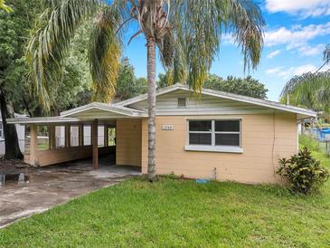 Charming single-story home with a covered parking area and lush landscaping at 1740 Inman Nw Dr, Winter Haven, FL 33881