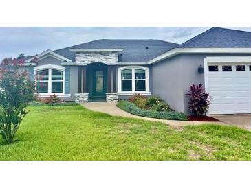 Charming single-story home featuring a stone accent entrance and a well-manicured front yard at 7144 Remington Oaks Loop, Lakeland, FL 33810