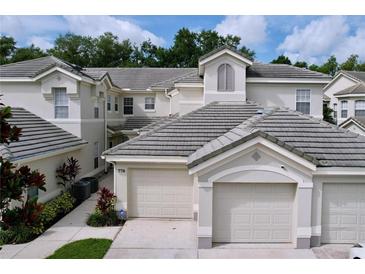 Charming townhouse featuring a tile roof, two-car garage, and well-maintained landscaping at 776 Grasslands Village Cir # 776, Lakeland, FL 33803