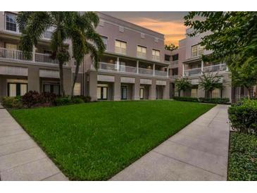 Beautiful courtyard with green grass and sidewalks surrounded by apartments with balconies at 539 Water St # 539, Kissimmee, FL 34747