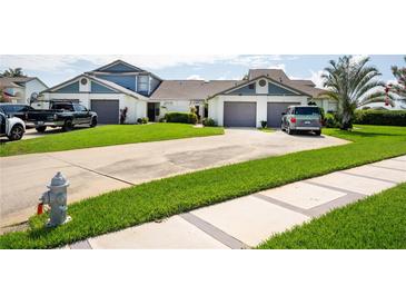Well-maintained townhome featuring attached garages, manicured lawn and long driveway at 62 Lakepointe Cir, Kissimmee, FL 34743