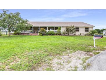 Ranch style home with large, green front yard and charming covered front porch at 124 Pangola Dr, Winter Haven, FL 33880