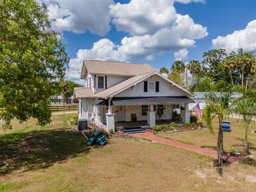 Charming two-story home with a brick walkway, landscaped yard, and a covered front porch at 4145 Willis Rd, Mulberry, FL 33860