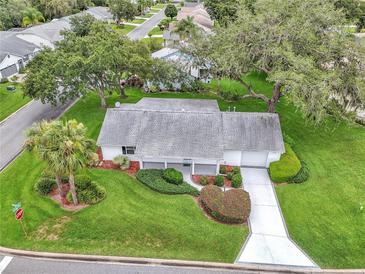 Charming single-story home features manicured lawn, mature trees, and a welcoming front porch at 5402 Rosewall Cir, Leesburg, FL 34748