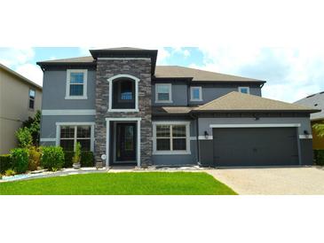 Beautiful two-story home with a stone-accented entrance and well-manicured lawn at 1319 Heavenly Cv, Winter Park, FL 32792
