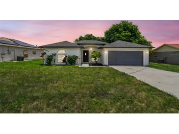Charming single-story home with stucco exterior, arched windows, and a well-maintained lawn at 1003 Edmund Ave, Dundee, FL 33838