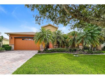 Charming home featuring a well-manicured lawn, mature landscaping, and a welcoming front entrance at 154 Indian Wells Ave, Kissimmee, FL 34759