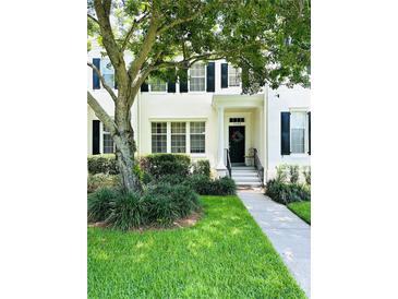 Inviting two-story home features lush landscaping, a charming front porch, and classic black shutters at 5489 Baldwin Park St, Orlando, FL 32814