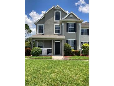 Charming two-story home with a covered front porch, fresh landscaping, and a well-maintained lawn at 9053 Lee Vista Blvd # 1405, Orlando, FL 32829