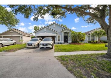 Charming single-story home with well-manicured lawn and driveway parked with vehicles at 4931 Jetton Dr, Orlando, FL 32837