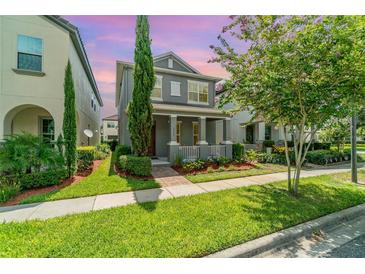 Charming two-story home with well-manicured lawn and inviting front porch with decorative columns at 9349 Mira Valle Ln, Winter Garden, FL 34787