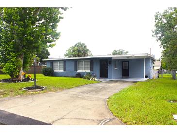 Charming single-story home with a well-manicured lawn and a driveway leading to a covered carport at 5 Moonlight Ln, Winter Haven, FL 33884