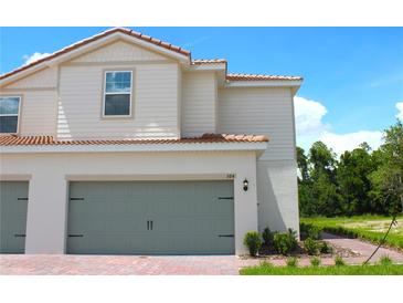 Charming two-story home featuring a two-car garage, beautiful landscaping and a welcoming red brick walkway at 584 Bay Leaf Dr, Poinciana, FL 34759