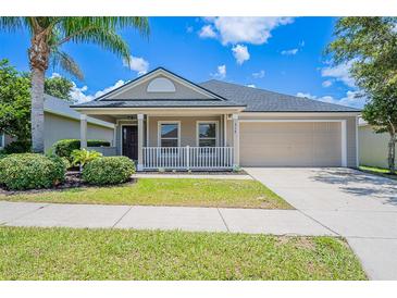 Charming single-story home with a covered front porch, landscaped yard, and a two-car garage at 316 Red Kite Dr, Groveland, FL 34736
