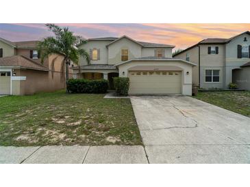 Inviting two-story home with a lush lawn and two-car garage, perfect for suburban living at 16828 N Gold Star Ct, Clermont, FL 34714