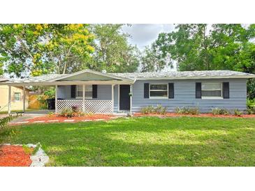 Charming single-story home featuring a well-manicured lawn, tasteful landscaping, and a cozy covered front porch at 5834 Forest Grove Blvd, Orlando, FL 32808