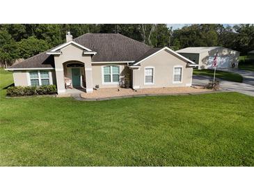 Charming single-story home with a well-manicured lawn and neutral-toned exterior at 33632 Wesley Rd, Eustis, FL 32736