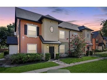 Charming townhouse featuring colorful accents, a well-maintained lawn, and mature landscaping at 6017 Westgate Dr # 924, Orlando, FL 32835