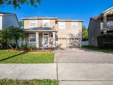 Charming two-story home featuring a well-manicured lawn and a two-car garage at 10084 Moss Rose Way, Orlando, FL 32832