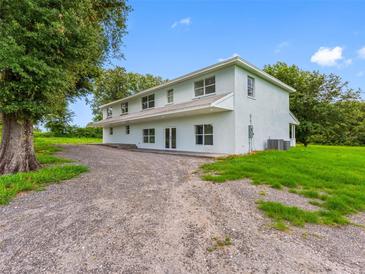 Spacious two-story home with ample parking and verdant landscaping, offering a serene and private setting at 2440 S Wallace Rd, Bartow, FL 33830