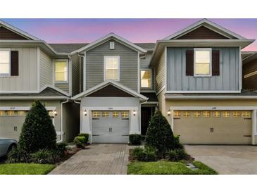 Charming townhomes with well-maintained landscaping, brick-paved driveways, and attached two-car garages at 1143 Presidential Ln, Apopka, FL 32703