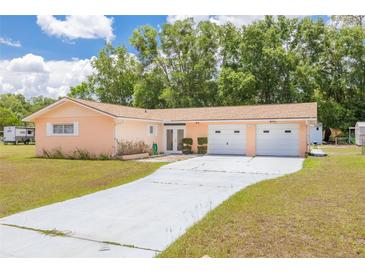 Charming single-story home features an attached two-car garage and long driveway with ample parking at 21078 Sw Honeysuckle St, Dunnellon, FL 34431