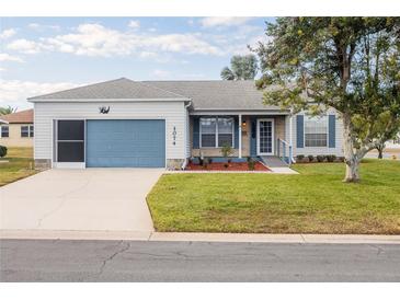 Charming single-story home featuring a blue garage door and front door, nicely landscaped front yard, and stone accents at 1074 Canary S Cir, Lakeland, FL 33809