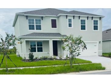 Charming two-story home with a manicured lawn and a two-car garage, inviting and well-maintained at 5543 Siltstone St, Lakeland, FL 33811