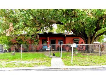 Charming single-story home with a chain-link fence, a well-maintained lawn, and mature trees providing shade at 605 Montana Ave, Lakeland, FL 33815