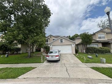 Charming two-story home featuring a two-car garage, well-maintained lawn, and mature shade tree at 606 Carrigan Woods Trl, Oviedo, FL 32765